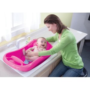 The First Years Sure Comfort Deluxe Newborn To Toddler Tub, Pink with infant having bath
