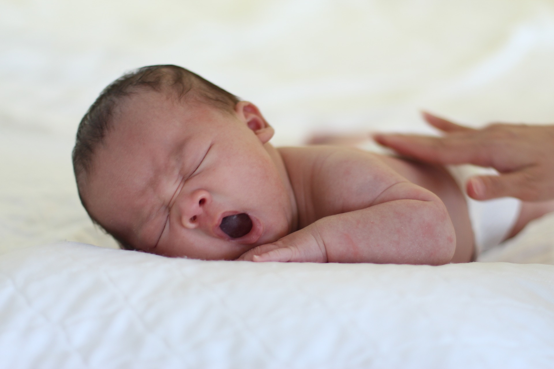 sleepy baby yawning - possible cause of low milk flow